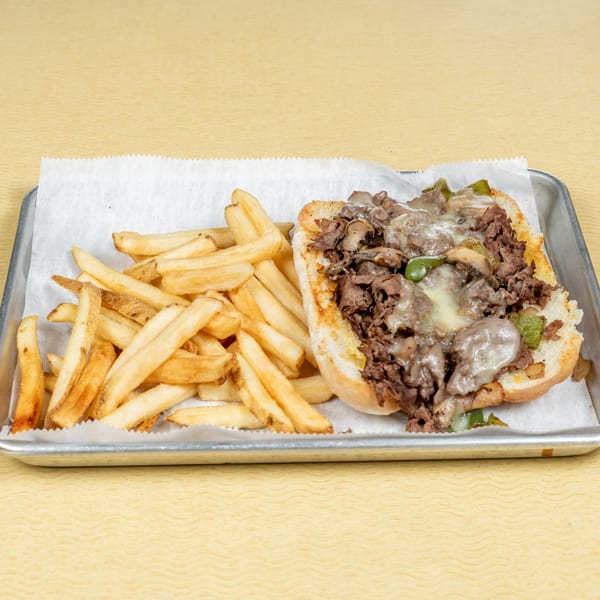 A Players Locker Room cheesesteak with melted cheese, peppers, and onions, served with a side of fries.
