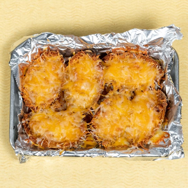 Four cheesy potato skins in a foil-lined metal tray, ready to be served at Players Locker Room.